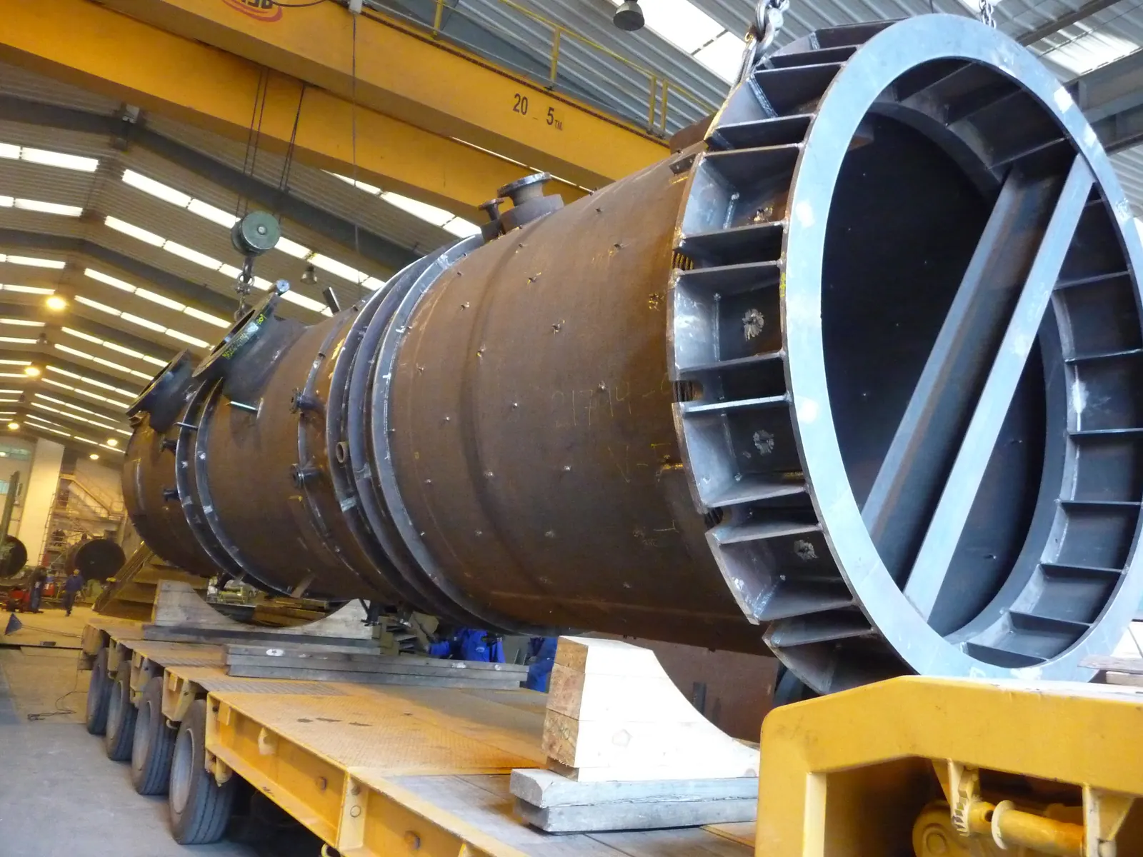 Columna de gran diámetro cargada sobre transporte especial en la nave, con la brida de cierre a la vista