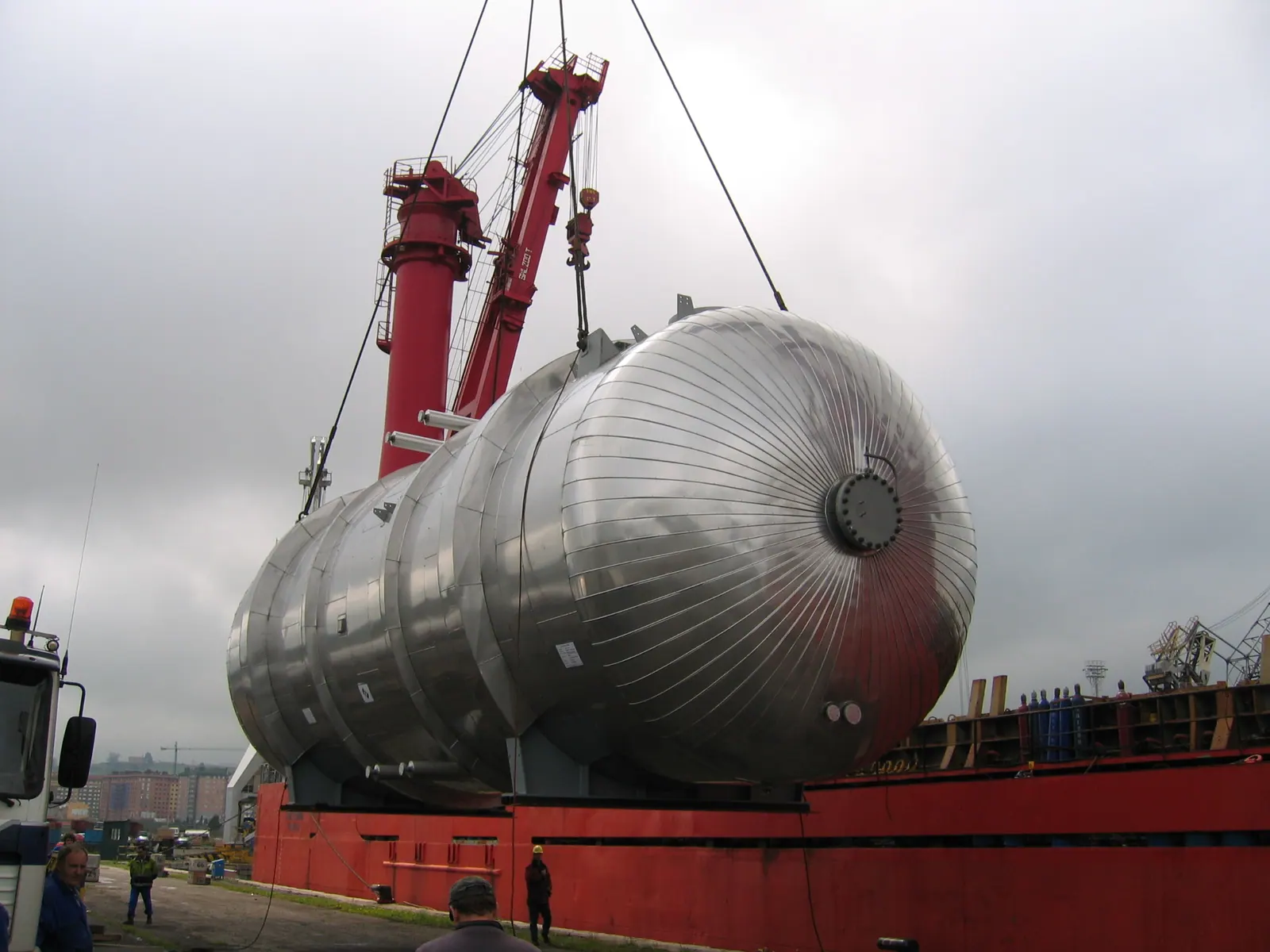 Izado de un evaporador de acero inoxidable de gran diámetro en muelle